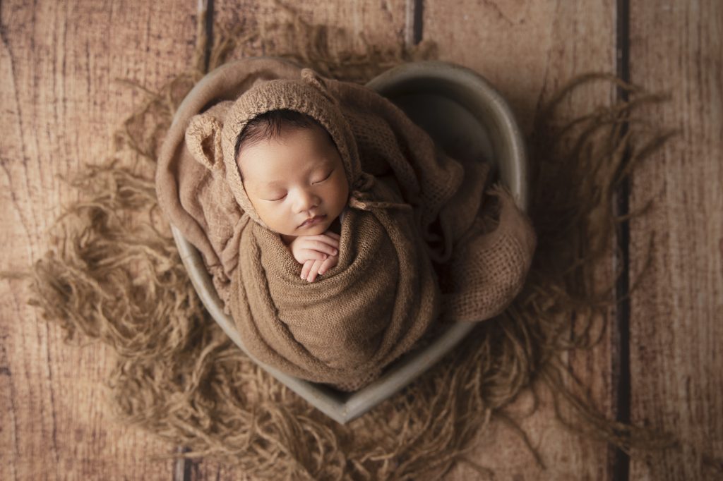 Cute baby boy was posed during his newborn photoshoot at our Sydney studio.