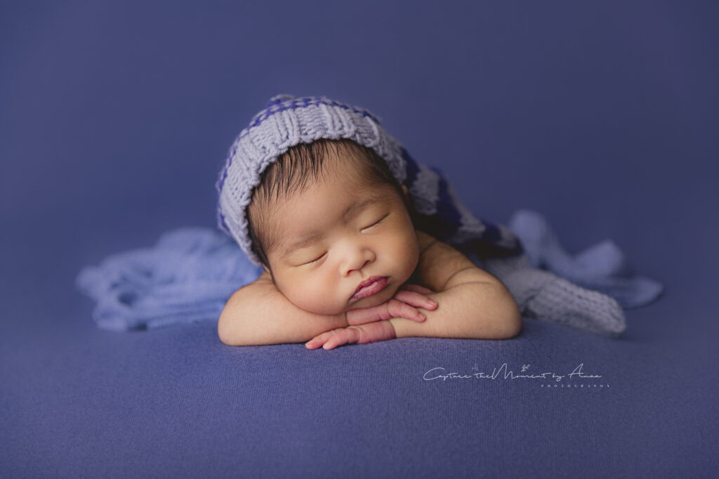 Newborn photography in Sydney. A baby boy was posed on blue background for his newborn photoshoot in Sydney.